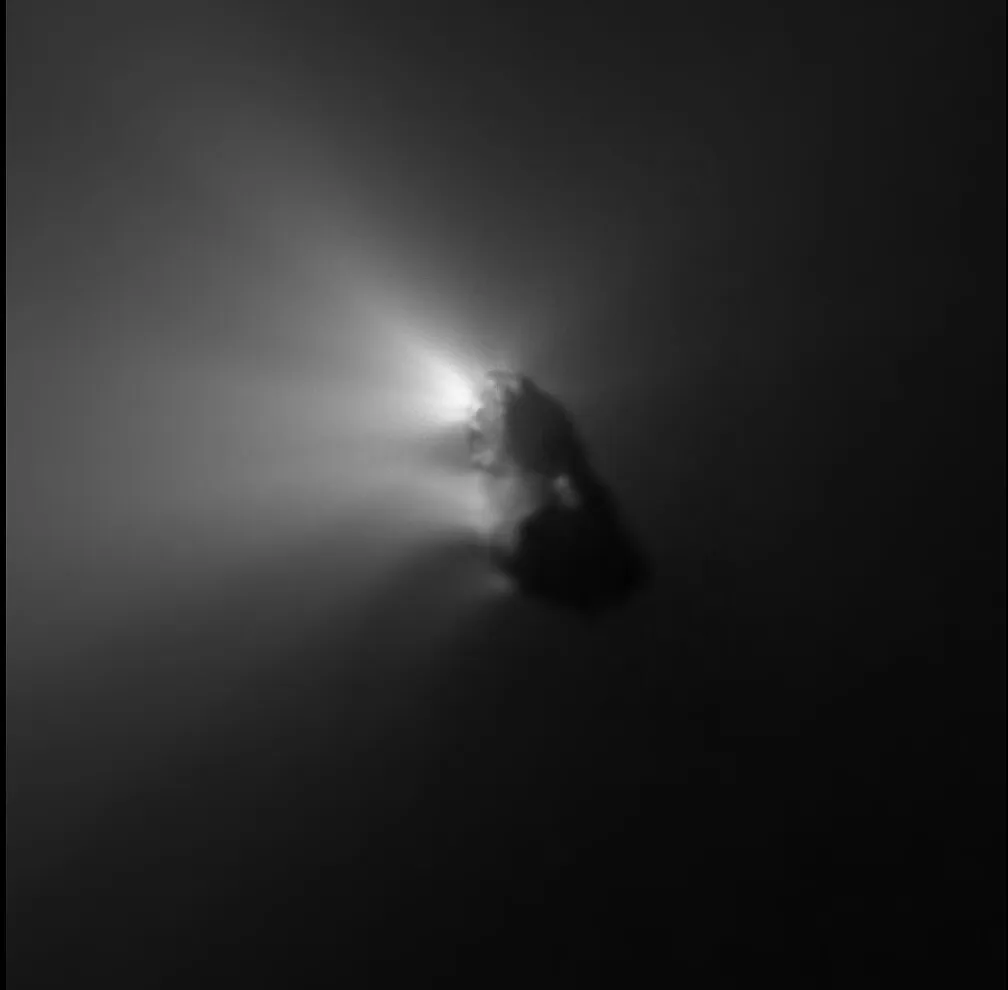 Imagen en blanco y negro de un cuerpo oscuro e irregular del que salen chorros de luz hacia la izquierda.
