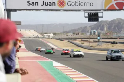 Autos compiten en el circuito del Villicum bajo un cartel del Gobierno de San Juan.