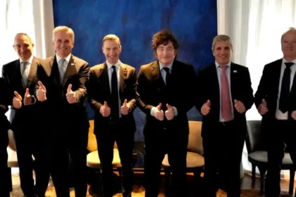 Javier Milei y otros hombres de traje posan haciendo pulgar arriba.