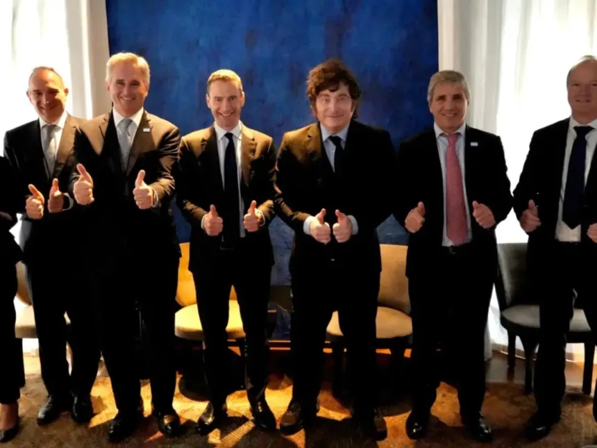 Javier Milei y otros hombres de traje posan haciendo pulgar arriba.