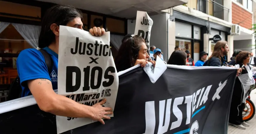 Manifestantes sostienen carteles y una bandera con reclamos de justicia.