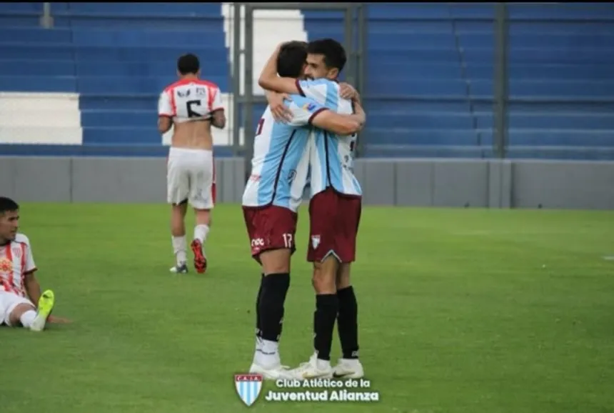 Dos jugadores de Alianza se abrazan para celebrar un gol en la cancha.