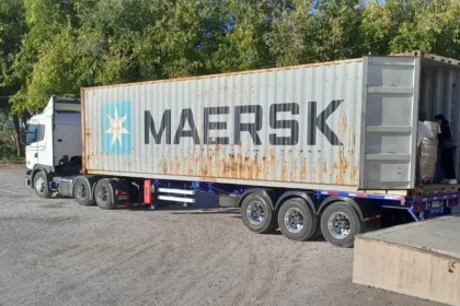 Un camión lleva un contenedor abierto de Maersk en un predio.