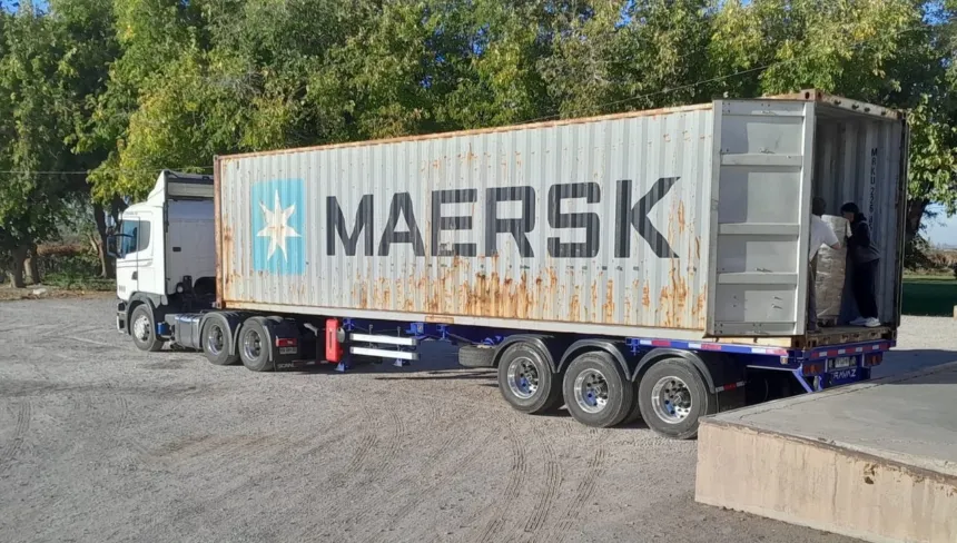Un camión lleva un contenedor abierto de Maersk en un predio.
