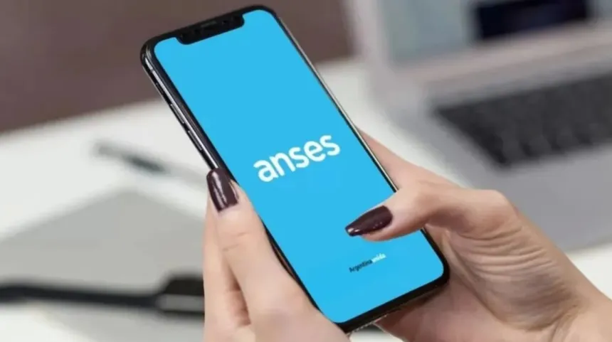 Manos sostienen un celular con la aplicación de ANSES abierta.