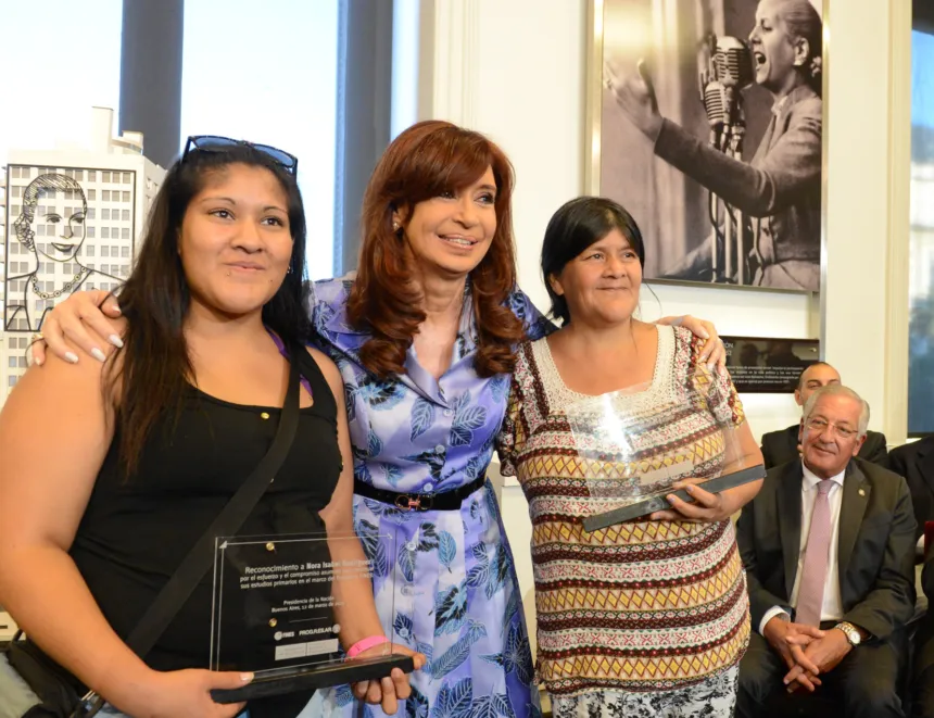 Cristina Fernández posa con dos beneficiarias del plan Progresar durante un acto.