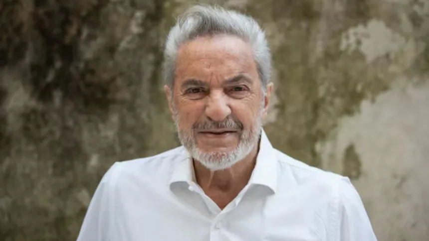 Antonio Grimau posa con camisa blanca frente a un fondo de vegetación.