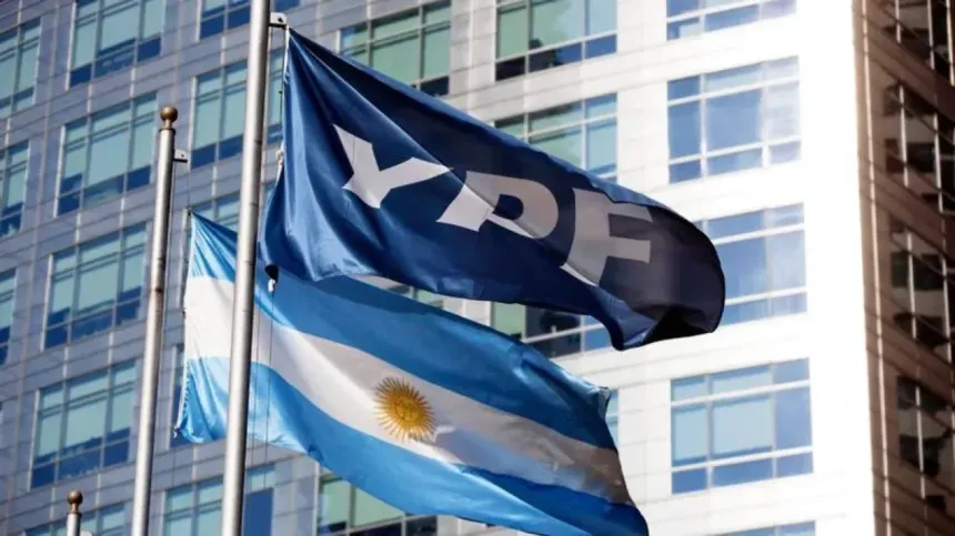 Bandera de YPF y bandera argentina frente a un edificio de oficinas.
