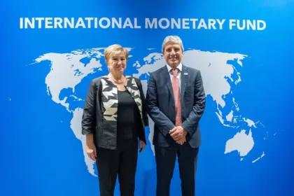 Kristalina Georgieva y un funcionario argentino posan ante un fondo del FMI.