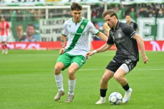 Futbolistas de Banfield y Argentinos Juniors disputan la pelota en la cancha.