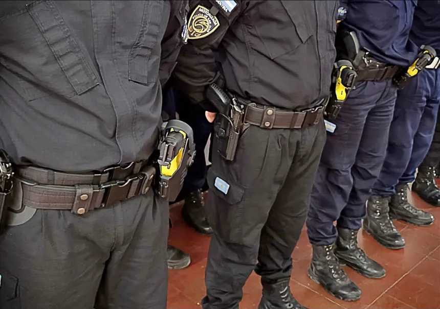 Policías uniformados con armas y equipos en sus cinturones.