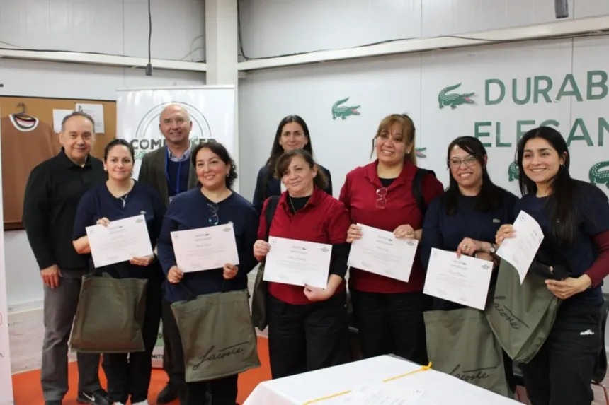 Adultos posan con certificados de capacitación en un local comercial.