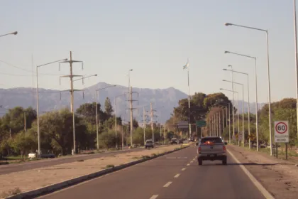 Ruta dividida con autos y montañas al fondo en Chimbas.
