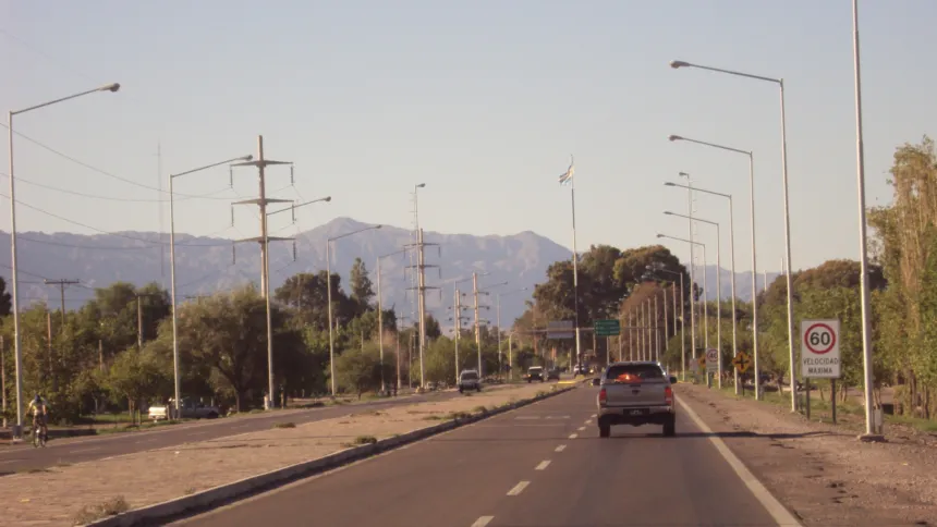 Ruta dividida con autos y montañas al fondo en Chimbas.