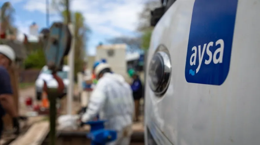 Vehículo de AySA junto a trabajadores que realizan tareas de mantenimiento.