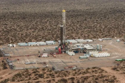 Una torre de perforación y equipos petroleros en un paisaje árido