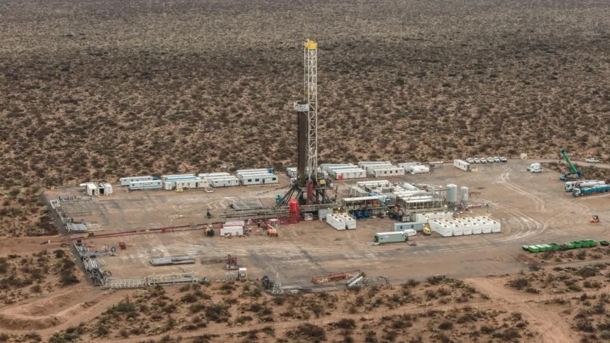 Una torre de perforación y equipos petroleros en un paisaje árido