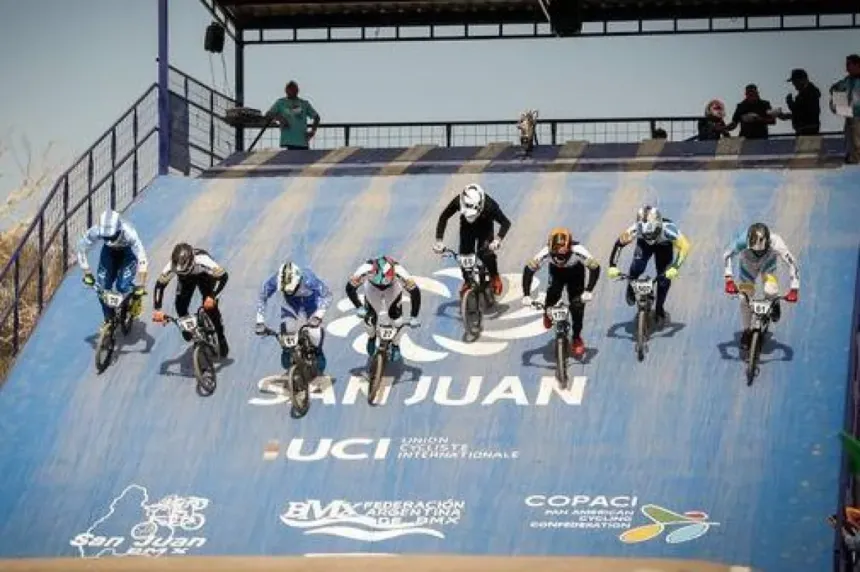 Pilotos de BMX descienden juntos por una pista en San Juan.