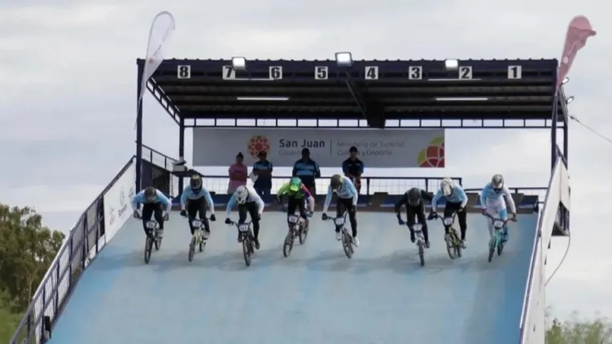 Ciclistas de BMX compiten en la rampa de una pista.