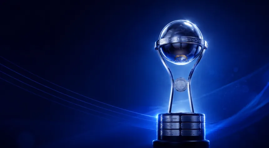 El trofeo de la Copa Sudamericana iluminado sobre un fondo azul oscuro.