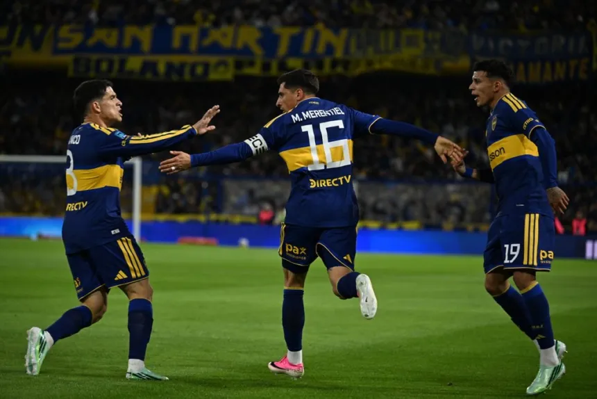 Tres jugadores de Boca celebran en el campo de juego.