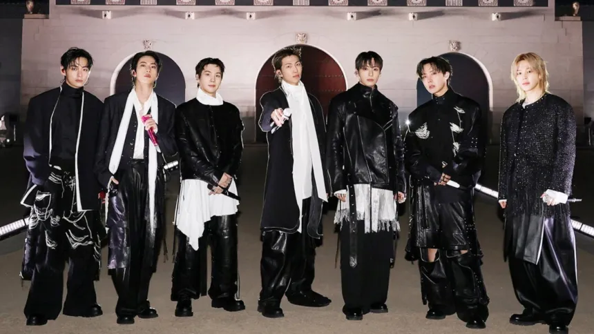 Los siete integrantes de BTS posan juntos con vestuario negro.