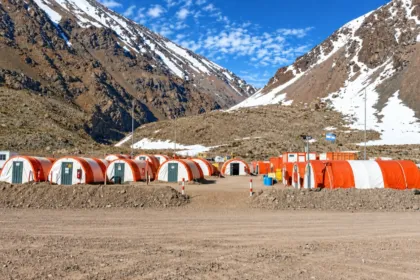 Carpas y módulos de campamento en un valle montañoso con nieve
