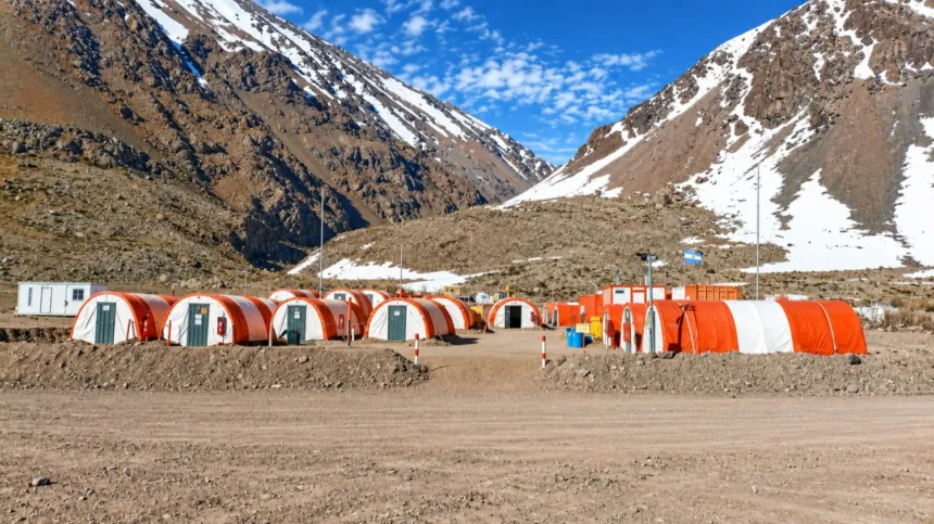 Carpas y módulos de campamento en un valle montañoso con nieve