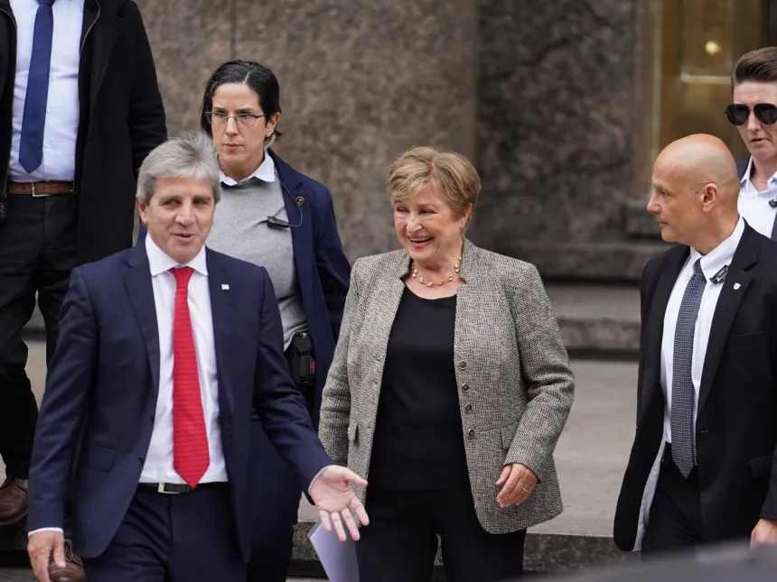 Luis Caputo camina junto a Kristalina Georgieva frente a un edificio.