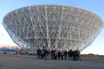 Un grupo posa frente a la antena del radiotelescopio CART en Calingasta.