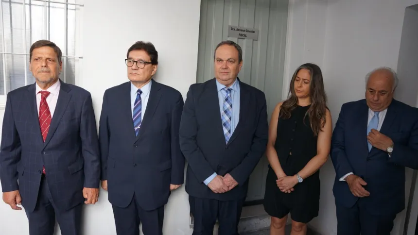 Cinco adultos posan en un pasillo institucional, junto a la puerta de un consultorio.