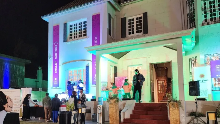 Fachada iluminada del Chalet Cantoni con personas reunidas en la entrada.