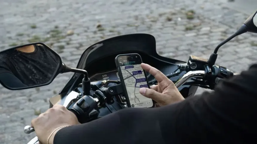 Un motociclista consulta un mapa en su celular mientras está en la moto.