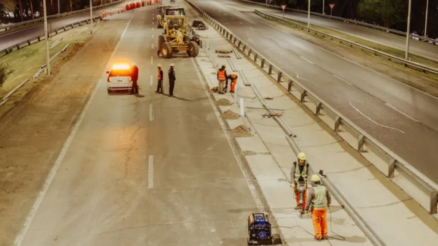 Obreros y maquinaria trabajan en la repavimentación de una avenida.