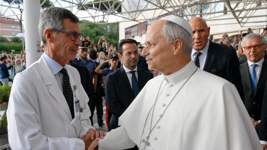 El papa León XIV saluda a un médico con bata blanca.