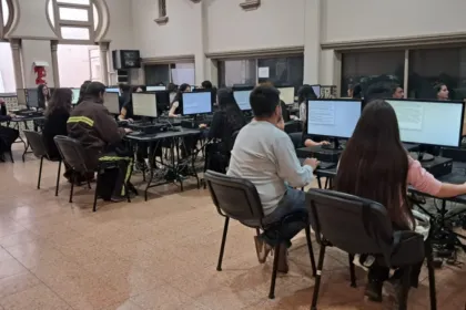 Personas sentadas frente a computadoras mientras rinden un examen.
