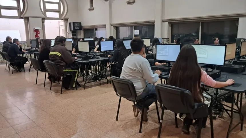 Personas sentadas frente a computadoras mientras rinden un examen.