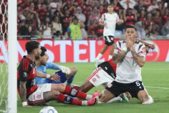 Futbolistas de Flamengo y Estudiantes disputan la pelota durante un partido.