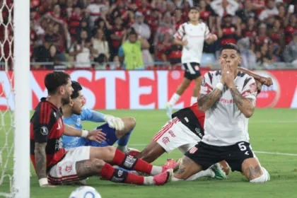 Futbolistas de Flamengo y Estudiantes disputan la pelota durante un partido.