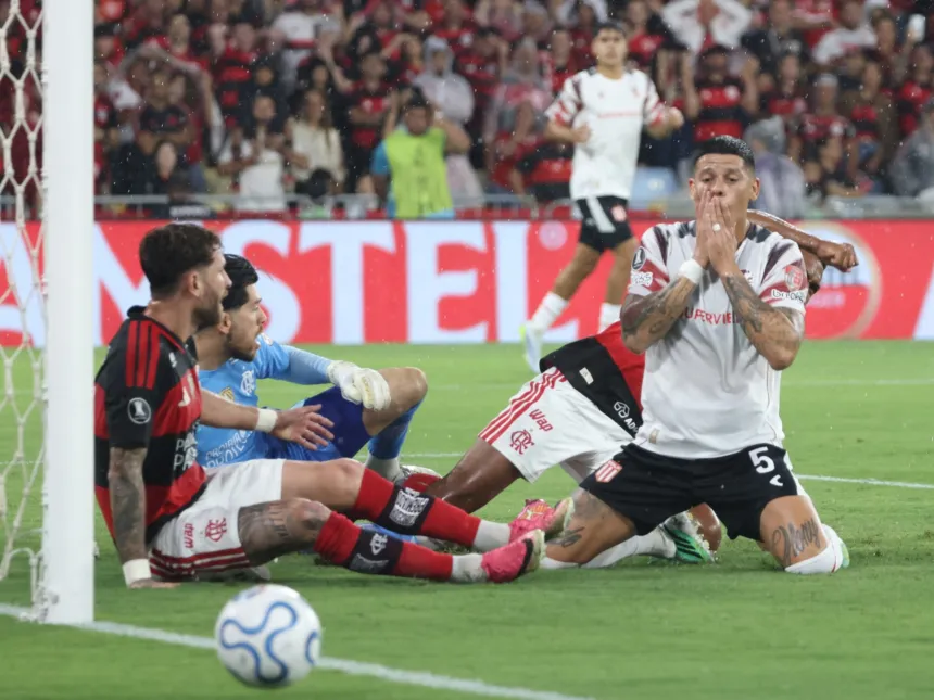 Futbolistas de Flamengo y Estudiantes disputan la pelota durante un partido.