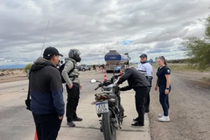 Personal de seguridad vial inspecciona una motocicleta en un control vehicular junto a la ruta.