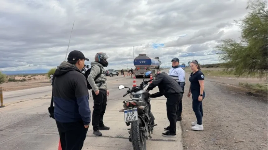 Personal de seguridad vial inspecciona una motocicleta en un control vehicular junto a la ruta.
