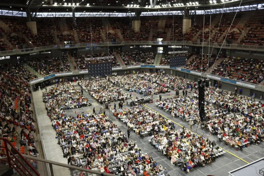 Miles de personas sentadas en un estadio techado durante una convención de los testigos de Jehová.