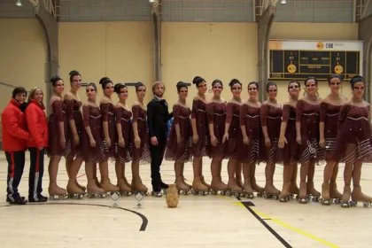 Patinadoras con vestuario de competición posan en una pista cubierta.