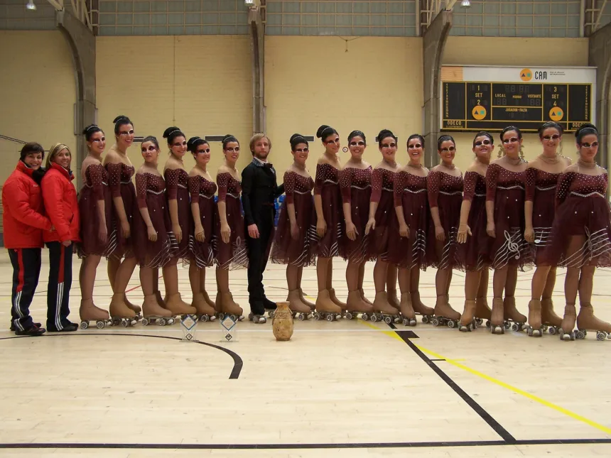 Patinadoras con vestuario de competición posan en una pista cubierta.
