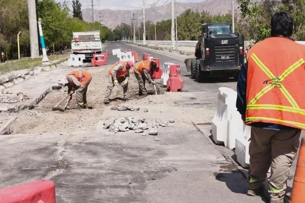 Personal vial trabaja sobre una avenida con maquinaria y barreras que delimitan el tramo en reparación.