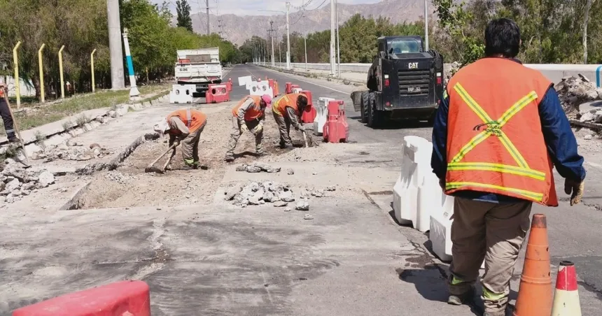 Personal vial trabaja sobre una avenida con maquinaria y barreras que delimitan el tramo en reparación.