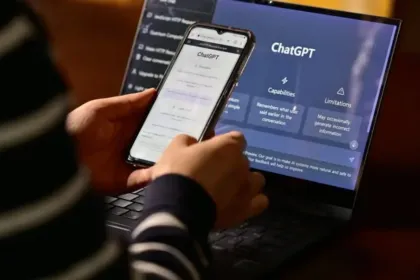 Una persona consulta ChatGPT desde un celular y una computadora portátil.