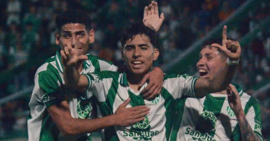 Tres jugadores de verde y blanco festejan un gol en la cancha.