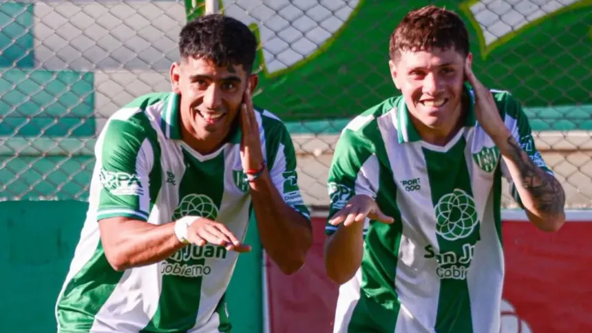 Dos jugadores de camiseta verde y blanca celebran en una cancha.